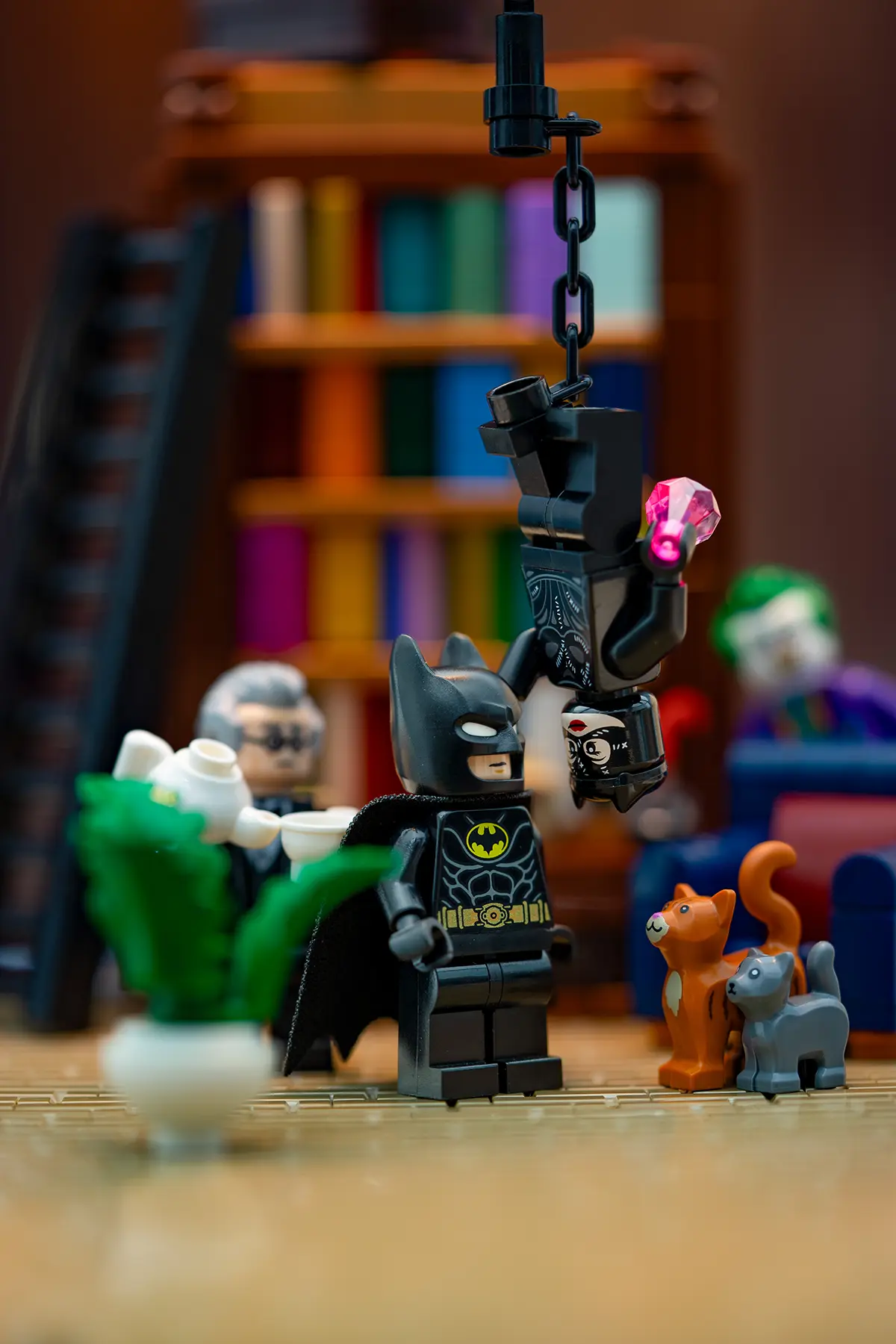 Batman faces an upside-down Catwoman in a cozy LEGO interior with Alfred and two cats nearby. The Support bar has been removed, and enhanced lighting brings warmth and clarity to the playful, domestic scene.