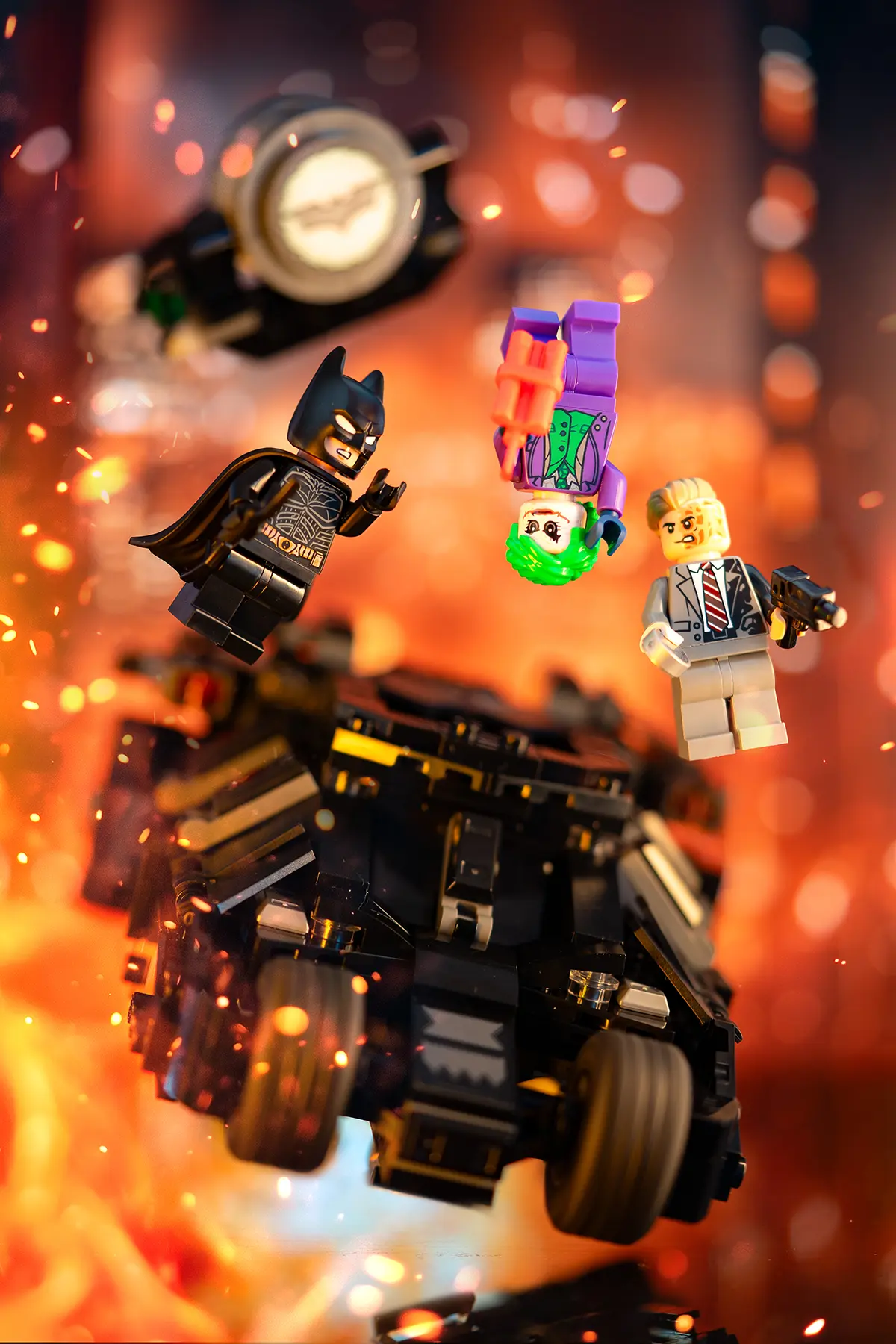 Batman, Joker, and Harvey Dent minifigures are captured in a fiery, explosive Gotham scene. All supports are removed, and added sparks, lighting, and contrast bring intense cinematic energy to the action.